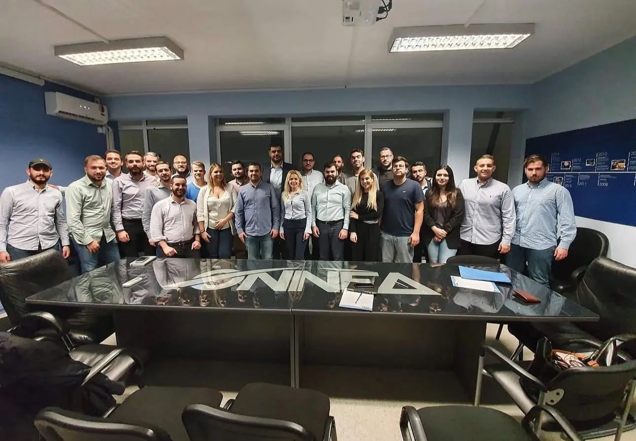 Στελέχη της ΟΝΝΕΔ γύρω από το τραπέζι συσκέψεων με το λογότυπο της οργάνωσης.